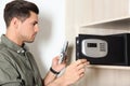 Man putting smartphone, passport and money into steel safe Royalty Free Stock Photo