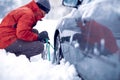 Man putting snow chains on car tire Royalty Free Stock Photo