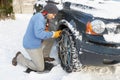 Man Putting Snow Chains Onto Tyre Of Car Royalty Free Stock Photo