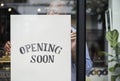 Man putting on store opening soon sign Royalty Free Stock Photo