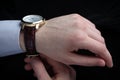 Man putting on wrist watch. Isoalted on black background