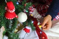 Man in pyjama decorating the Christmas tree indoors.