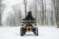 Man on a quad bike in winter background. Portrait of a quadricycle rider in snowy forest Royalty Free Stock Photo