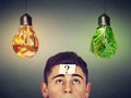 Man with question looking at junk food vegetables light bulbs Royalty Free Stock Photo
