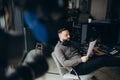 Man radio host or representer or journalist reads news from paper list in hand to studio microphone sitting at mixing Royalty Free Stock Photo