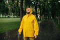 Man in raincoat enjoying the rain in summer park