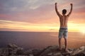 Man with raised arms standing on a cliff over the sea Royalty Free Stock Photo