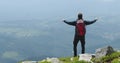The man raised his arms in victory, celebrating victory on top of the mountain. Royalty Free Stock Photo