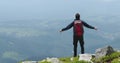 The man raised his arms in victory, celebrating victory on top of the mountain. Royalty Free Stock Photo