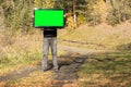 The man raised the TV to the level of his head, the screen is green for use