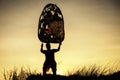 man raising Thai shadow angel puppet at mountain peak cliff