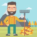 Man with rake standing near heap of autumn leaves.