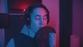 A man rapping through the pop-filter in the microphone - neon lighting