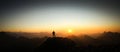 Man reaching summit enjoying freedom and looking towards mountains sunrise. Royalty Free Stock Photo