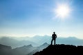 Man reaching summit enjoying freedom and watching towards mountain ranges. Royalty Free Stock Photo