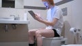 Man Reacting to Success on Tablet PC in Toilet, Commode