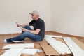Man reading assembly instructions for furniture in new house. Carpenter repair and assembling furniture at home