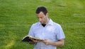 Man reading Bible in the grass. Royalty Free Stock Photo