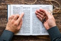 Man reading a bible and holding a cross Royalty Free Stock Photo