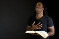 Man reading a bible isolated on black. Royalty Free Stock Photo