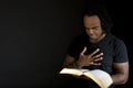 Man reading a bible isolated on black. Royalty Free Stock Photo