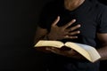 Man reading a bible isolated on black. Royalty Free Stock Photo