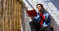 Man reading a book on the balcony of his house. Royalty Free Stock Photo