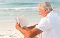 Man reading a book on the beach Royalty Free Stock Photo