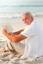 Man reading a book on the beach Royalty Free Stock Photo
