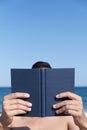 Man reading a book on the beach Royalty Free Stock Photo