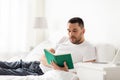 Man reading book in bed at home Royalty Free Stock Photo