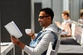 Man reading book and drinking coffee at city cafe Royalty Free Stock Photo