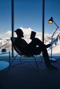 Man reading book in the hotel room with Mountain View Royalty Free Stock Photo