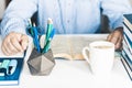 Man reading book on modern stylish work place with office supplies, glasses, notebooks and books, desk work concept in white and Royalty Free Stock Photo