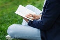 Man reading book in park. Writer, psychologist or student prepare for exam outside on green grass