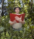 Man Reading Book in a Rainforest