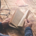 Man reading book sitting at a wooden table Royalty Free Stock Photo