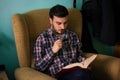 Man reading a book on sofa in his home