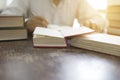 Man reading book with textbook stack on wooden desk Royalty Free Stock Photo