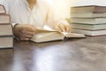 man reading book with textbook stack on wooden desk Royalty Free Stock Photo