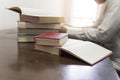 man reading book with textbook stack on wooden desk Royalty Free Stock Photo