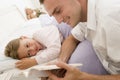 Man reading book to young girl in bed smiling Royalty Free Stock Photo