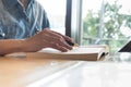 Man reading a book and writing notes on wooden table on sunset. Royalty Free Stock Photo