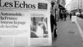 Man reading buying French Les Echos newspaper at press kiosk Street