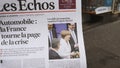 Man reading buying French Les Echos newspaper at press kiosk Street