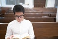 A man is reading the Holy Bible and praying in a worship room in a Christian church Royalty Free Stock Photo