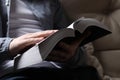 Man reading holy Bible on sofa, closeup Royalty Free Stock Photo