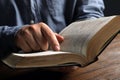 Man reading holy Bible at wooden table, closeup Royalty Free Stock Photo