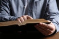 Man reading holy Bible at wooden table, closeup Royalty Free Stock Photo