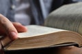 Man reading holy Bible at wooden table, closeup Royalty Free Stock Photo